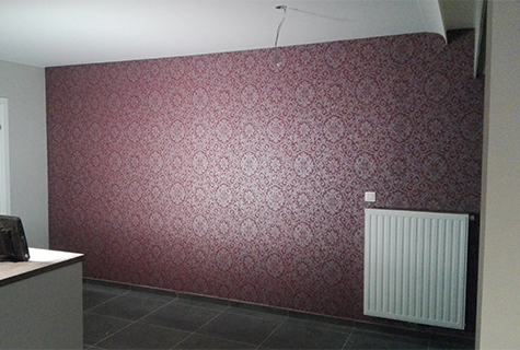 Behangwerken: muur met paars behangpapier.